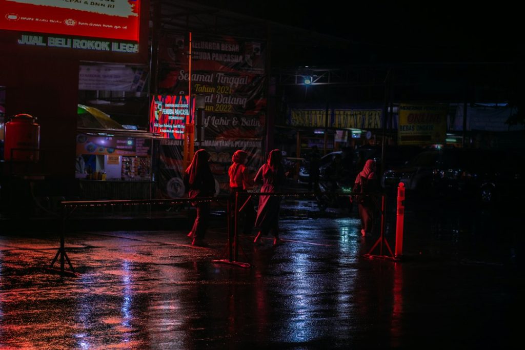 डार्क क्राइम ड्रामा के लिए रात में बारिश के बीच खड़े लोगों की प्रतीकात्मक तस्वीर