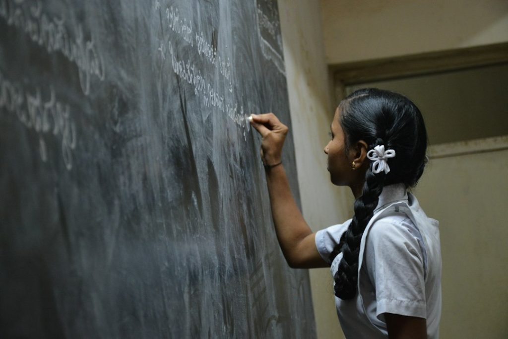 कक्षा में विद्यार्थियों को पढ़ाती हुई शिक्षिका