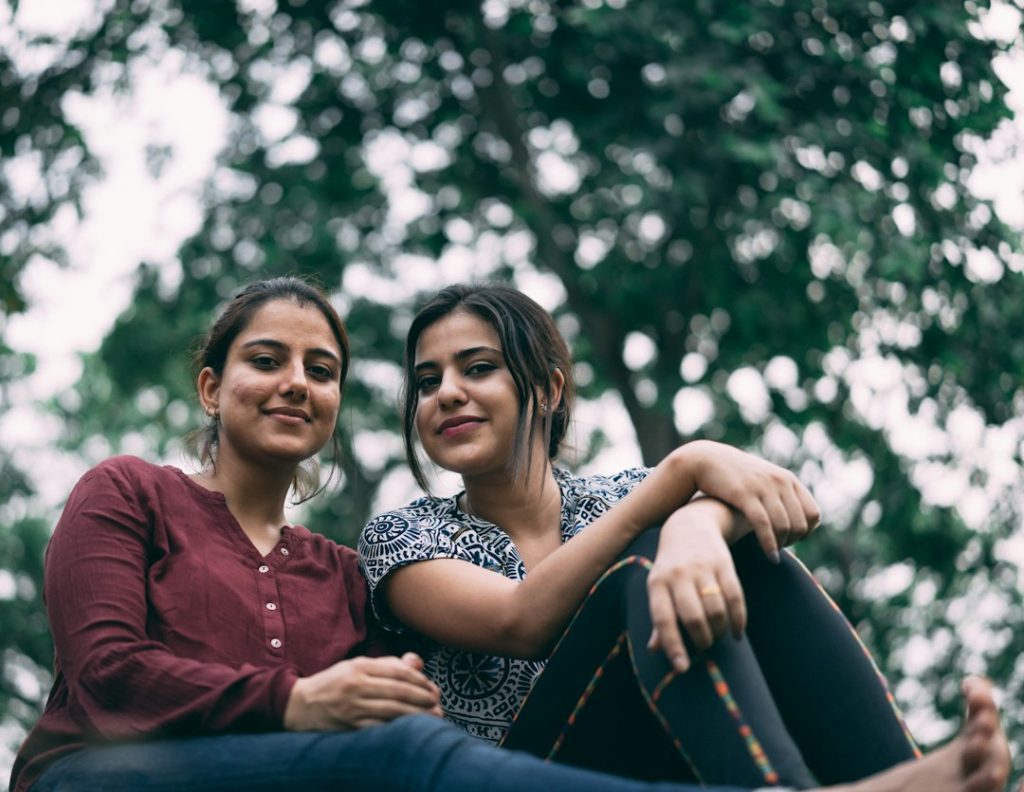 दो युवतियाँ साथ खड़ी हुईं, आधुनिक जीवनशैली और दोस्ती का प्रतीकात्मक चित्र