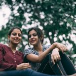 दो युवतियाँ साथ खड़ी हुईं, आधुनिक जीवनशैली और दोस्ती का प्रतीकात्मक चित्र