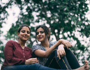 दो युवतियाँ साथ खड़ी हुईं, आधुनिक जीवनशैली और दोस्ती का प्रतीकात्मक चित्र